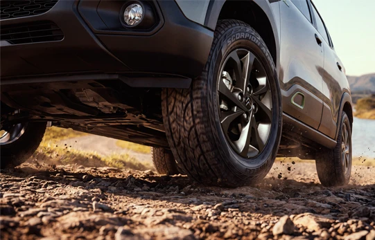Destaque para a roda do Citroën C3 XTR prateado em ação sob solo de grama e folhas.