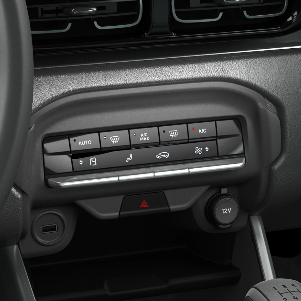 Painel central do Citroën C3 com saídas de ar, entrada USB, botão de pisca alerta e outros comandos do sistema interno. Tudo em preto, com detalhes cromados.